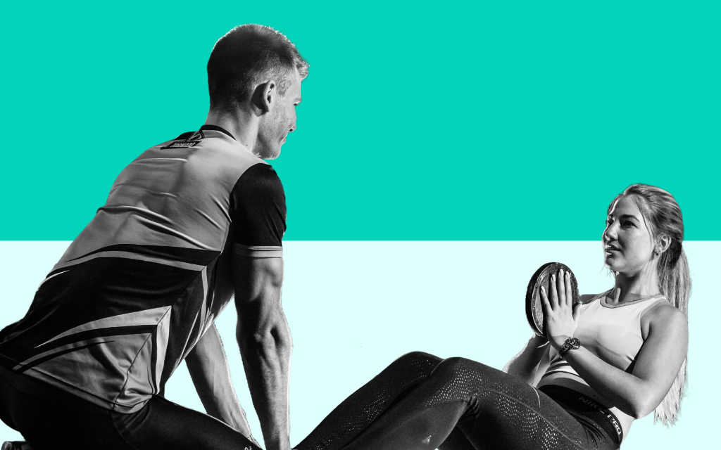 Personal trainer coaching a female client during a gym workout session, demonstrating professional fitness training in the UK