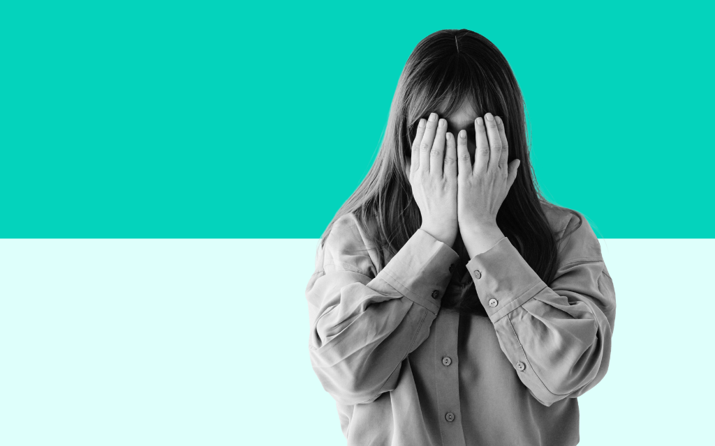 Woman covering her face with her hands representing mental health challenges and the importance of accessible wellbeing support for young people and learners